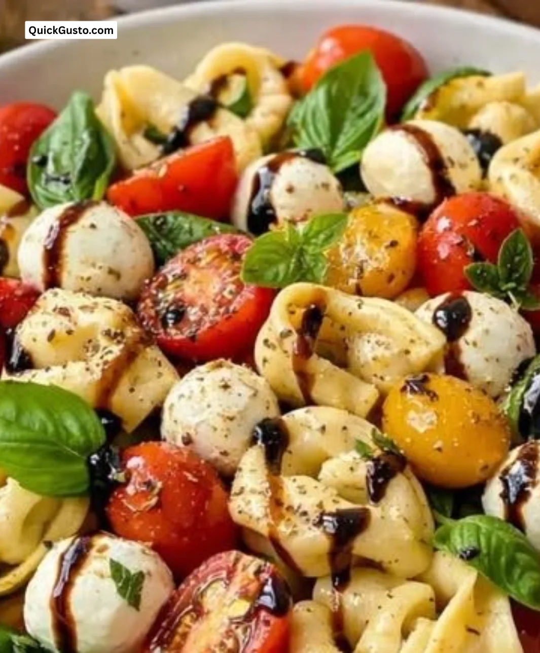 Colorful Tortellini Caprese Salad with tomatoes, mozzarella, and basil.