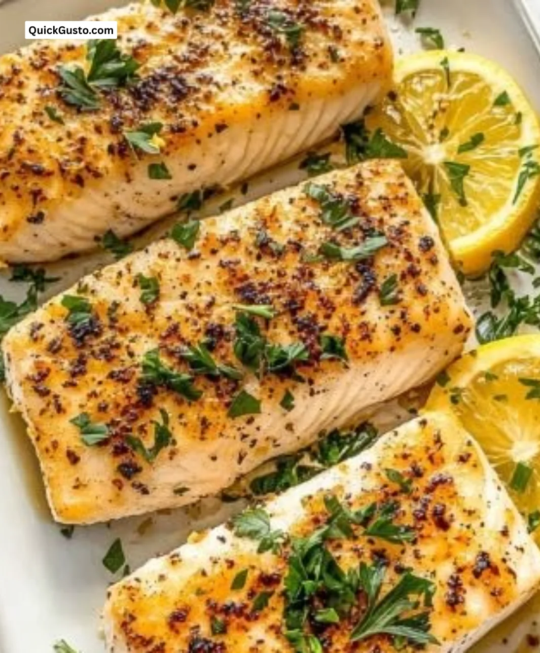 Brightly baked lemon butter mahi mahi served with herbs and lemon wedges