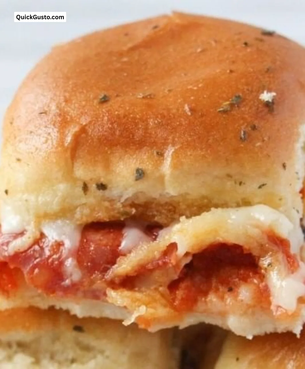 Cheesy pizza sliders in a baking dish, perfect for a delicious party appetizer.