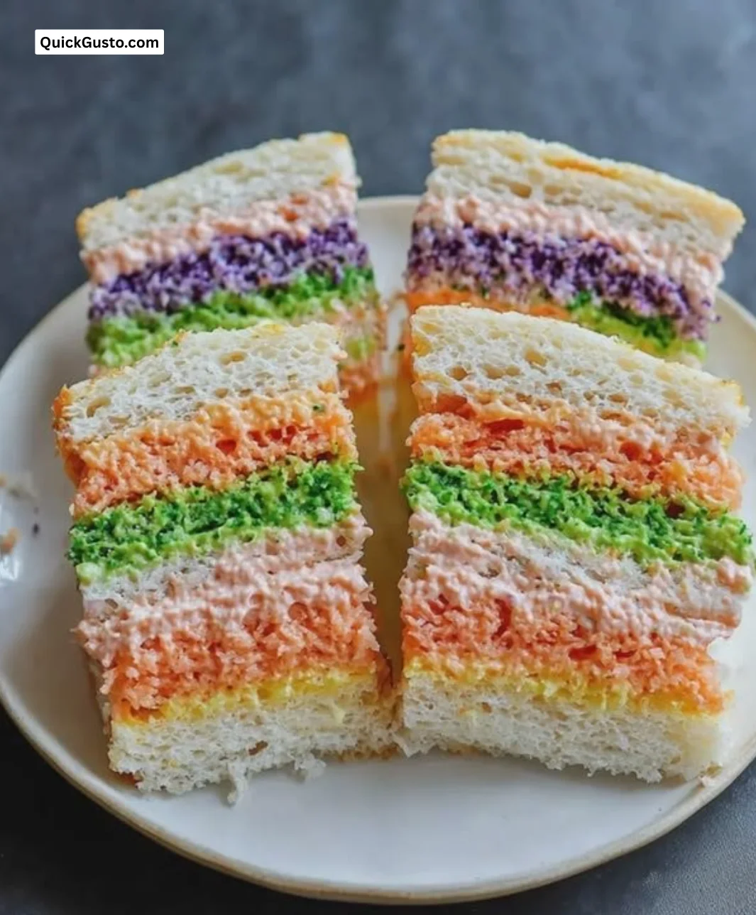 A variety of colorful tea sandwiches displayed on a platter.