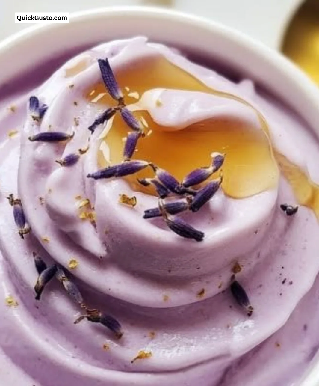 Creamy honey lavender frozen yogurt served in a bowl with lavender sprigs