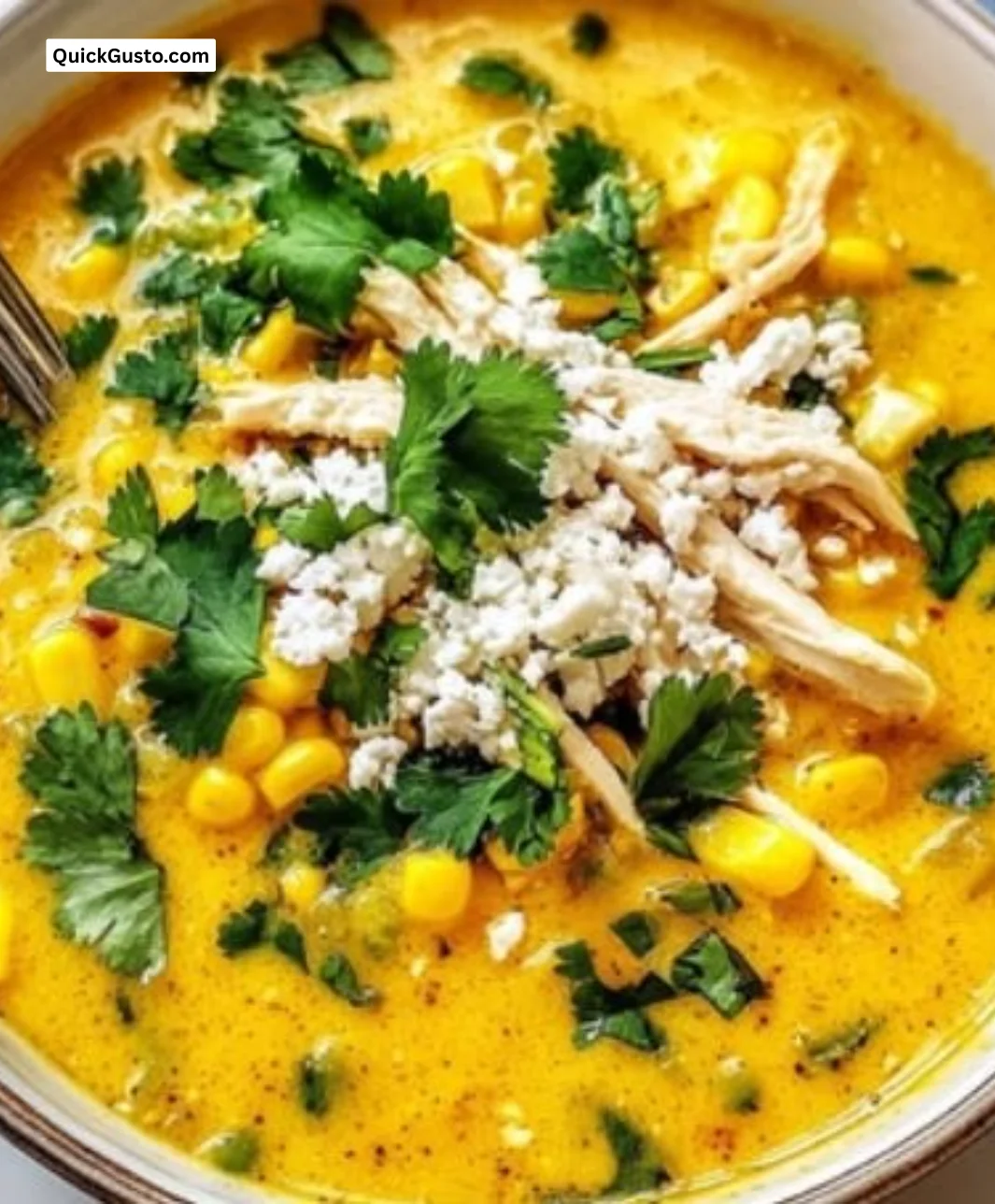 A bowl of creamy Mexican street corn soup garnished with fresh herbs and corn.