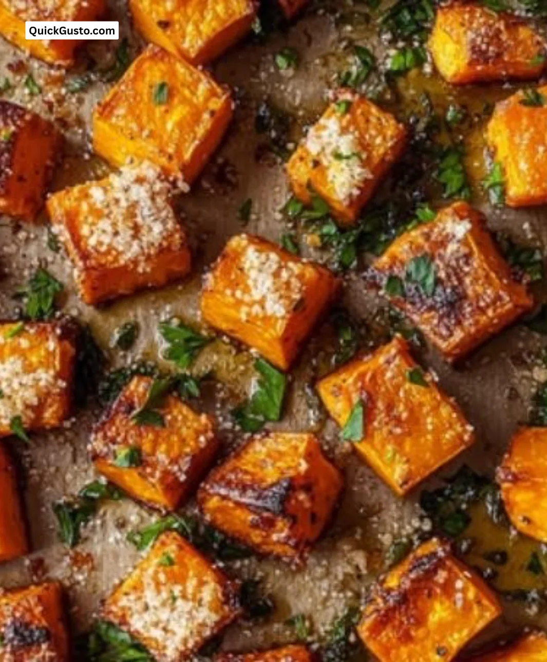 Crispy garlic parmesan roasted sweet potatoes garnished with herbs