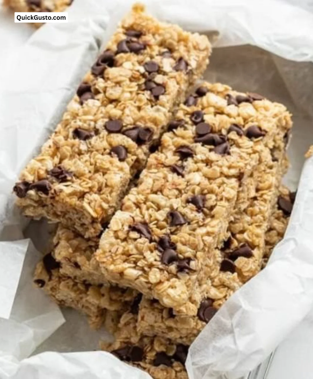 Plate of crunchy homemade granola bars topped with nuts and fruits