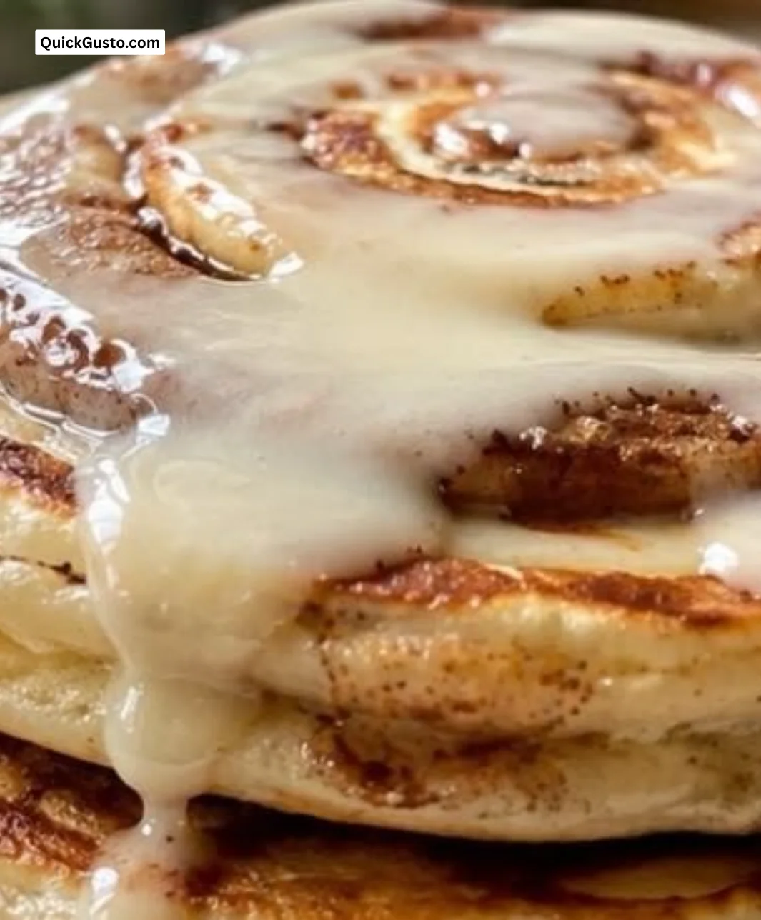 Plate of easy cinnamon roll pancakes drizzled with icing