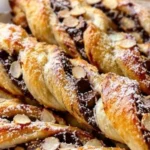 Assorted French breakfast pastries including croissants and tarts on a table.