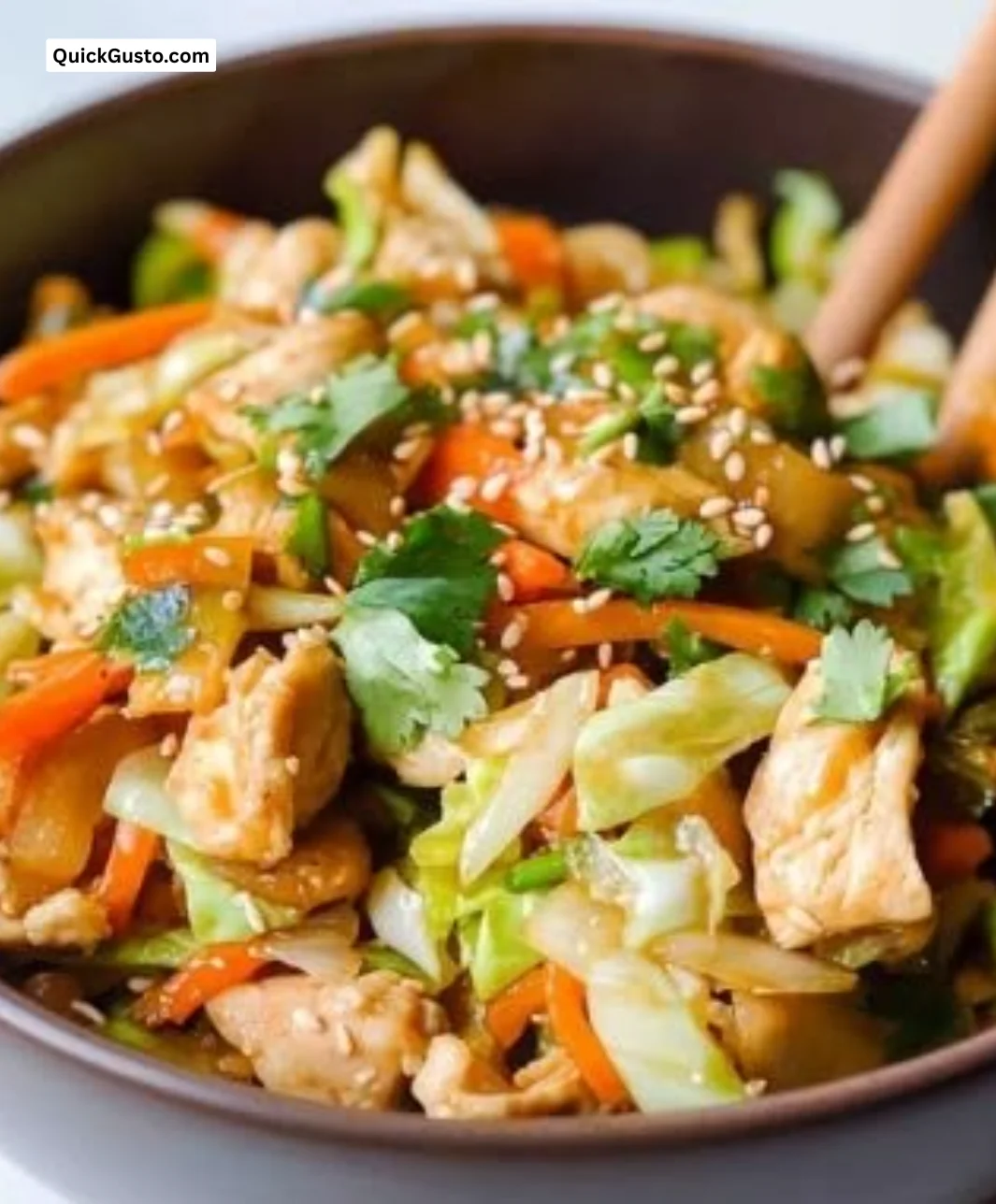 Healthy egg roll bowl with chicken, veggies, and savory sauce in a bowl