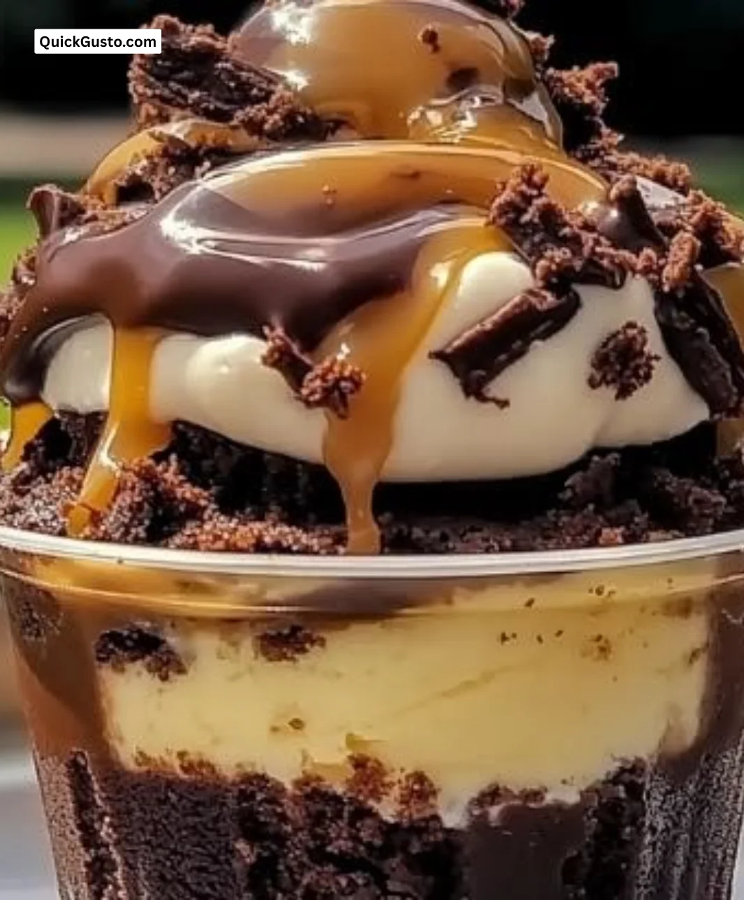 Delicious loaded brownie cheesecake cups topped with chocolate and cream.