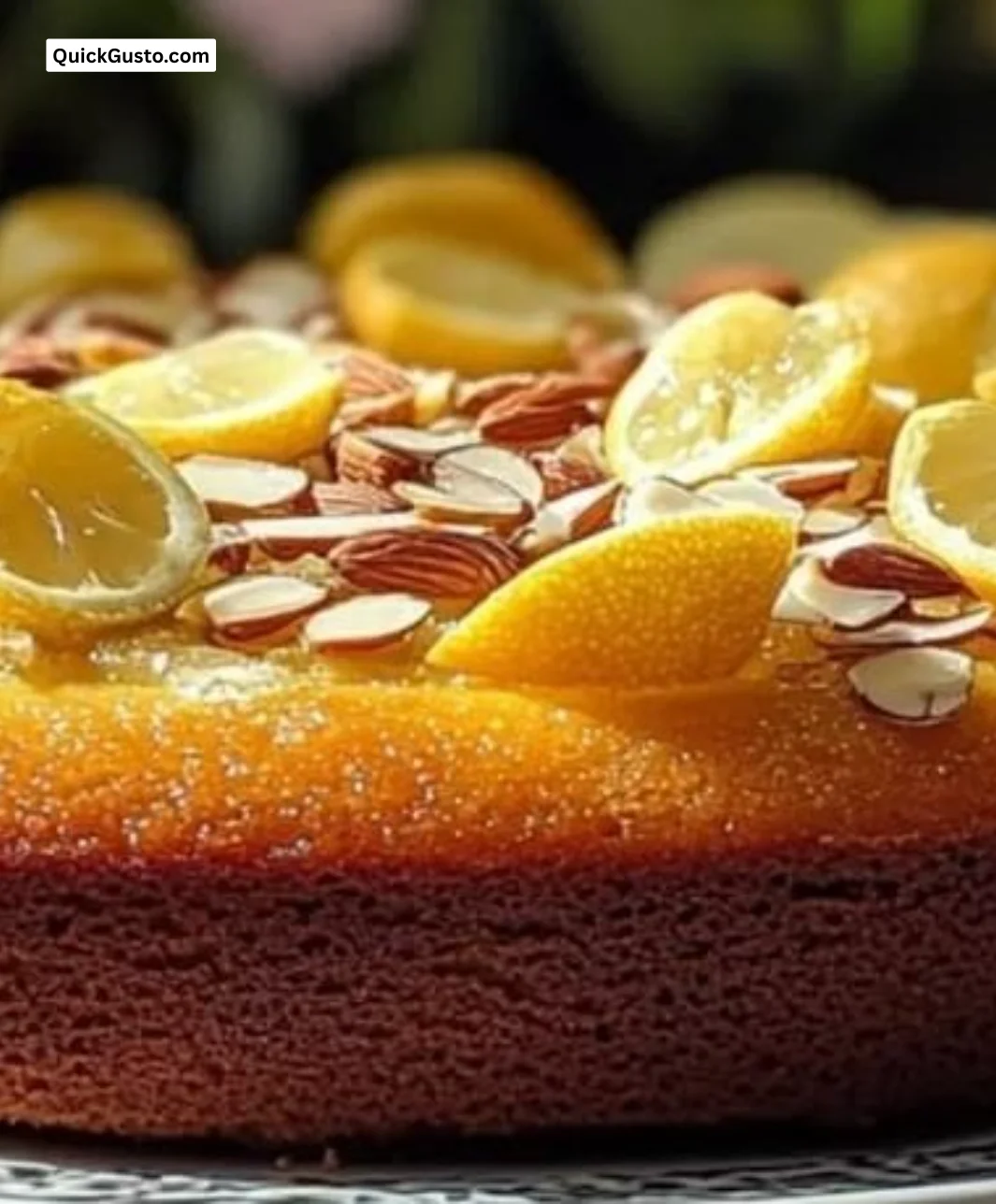 Slice of Lemon Almond Olive Oil Cake garnished with lemon zest and almonds