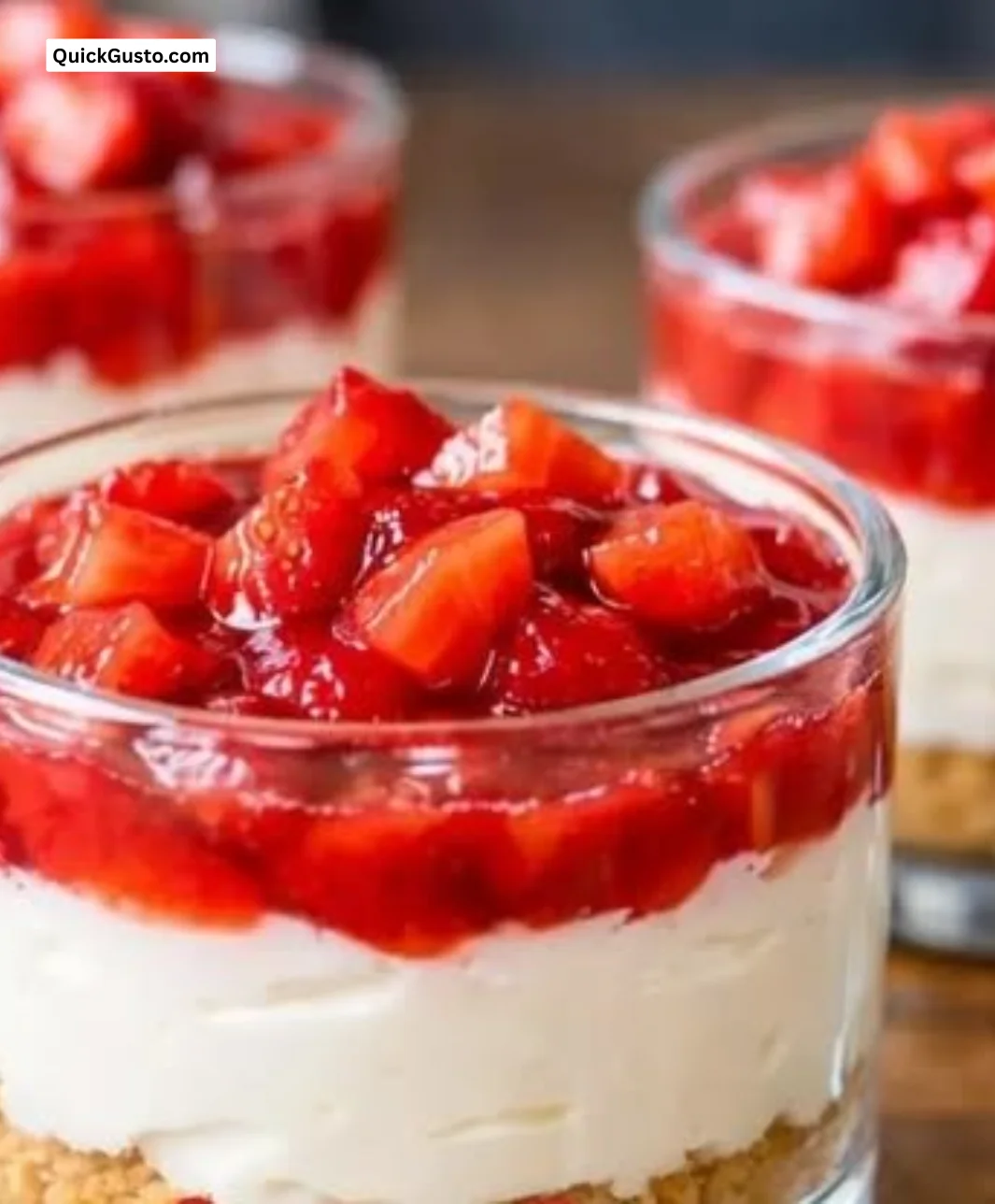 No-bake strawberry cheesecake dessert cups topped with fresh strawberries.