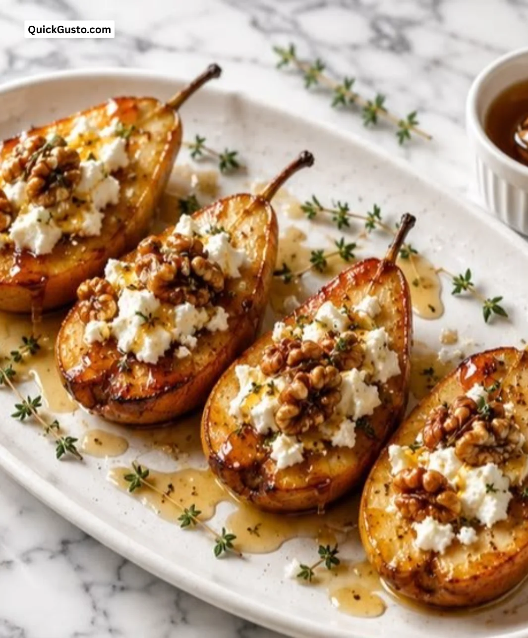 Roasted pears with goat cheese and maple walnut drizzle on a white plate