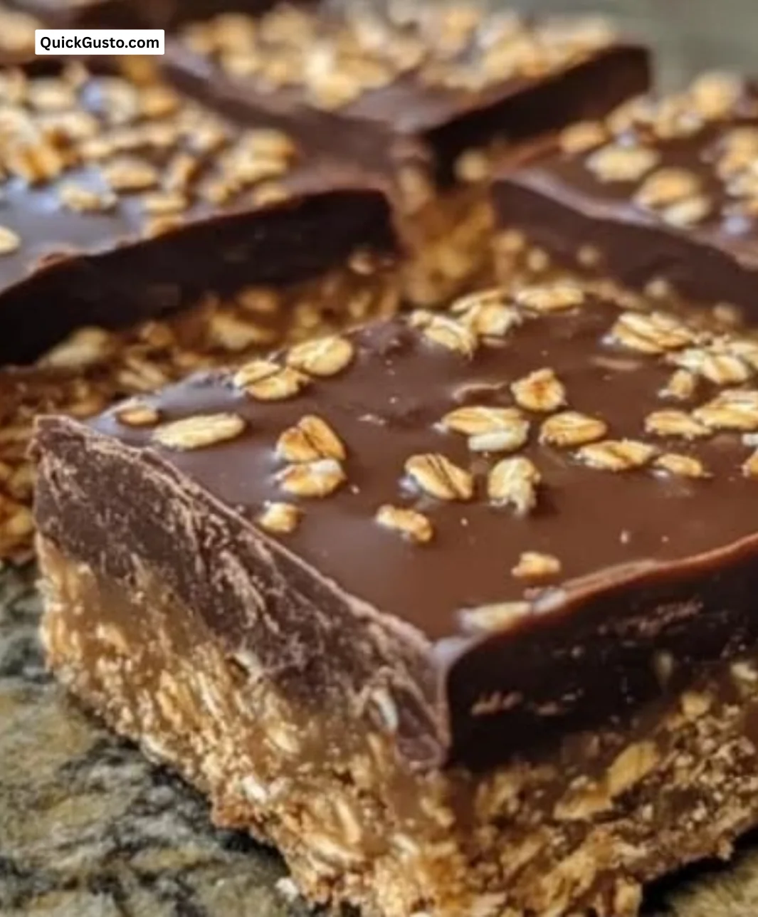 Salted dark chocolate tahini oat bars on a rustic wooden table