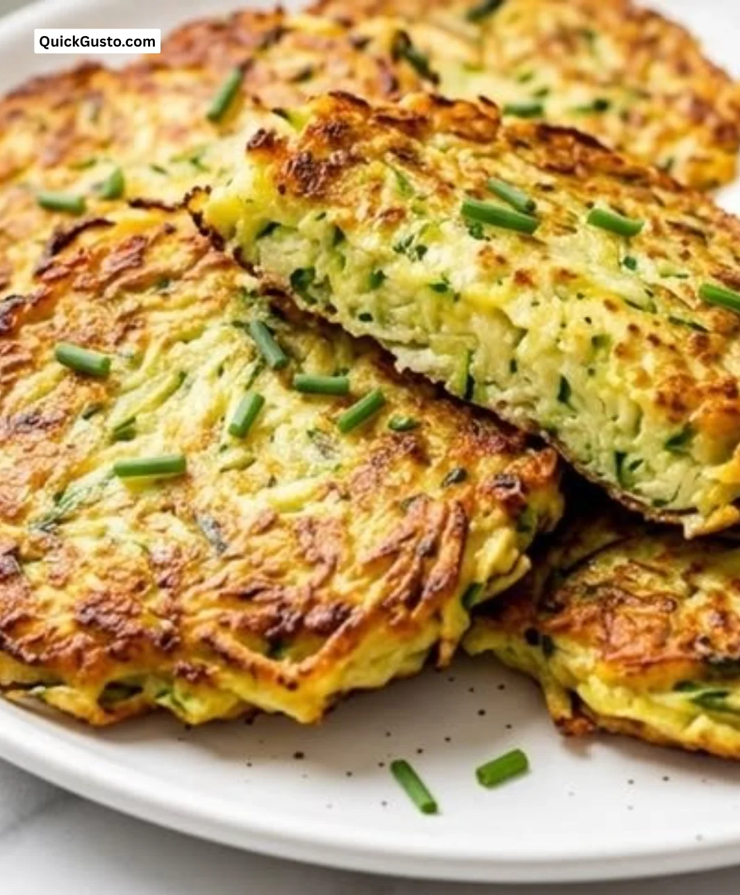Plate of crispy zucchini fritters garnished with herbs